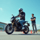 Jeune adulte passant l'examen pratique du permis moto 125cc dans un centre moderne